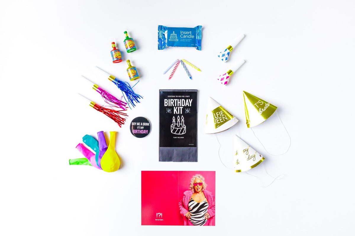 Birthday Kit pull from the mystery vending machine — hats, poppers, candles and balloons