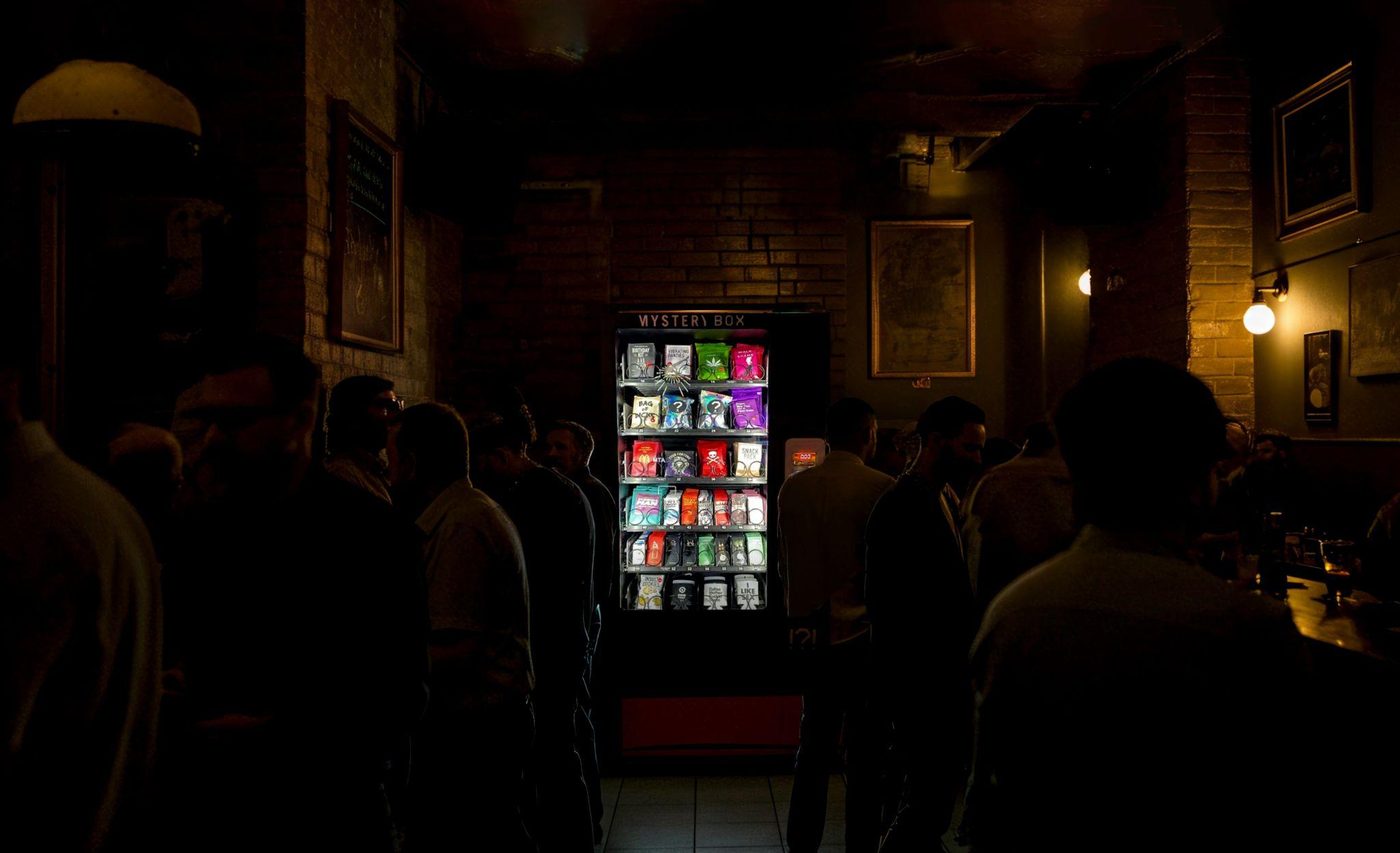 Mystery Box vending machine glowing in a crowded dark bar